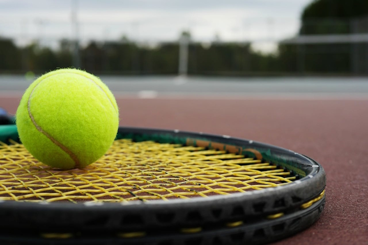 Tennis racket and ball on a court
