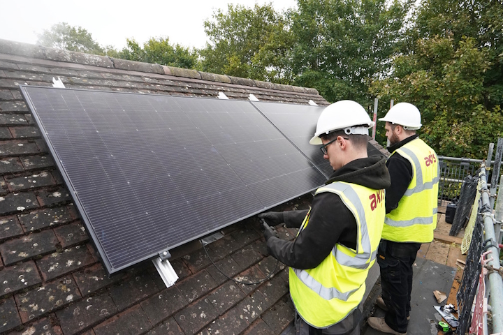 Installing photovoltaic solar panels on a roof as part of the net zero retrofit pilot project